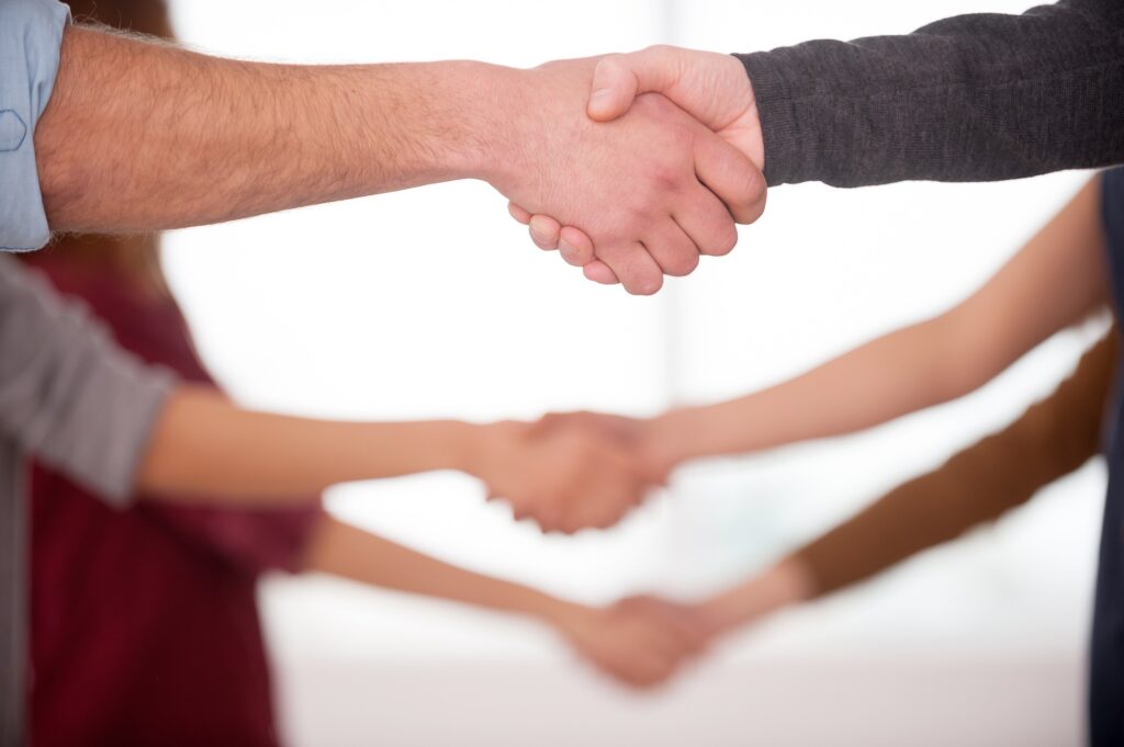 Handshaking. Close up of people handshaking while standing in a row