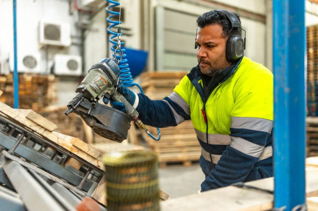 Man worker recycling pallets in a factory