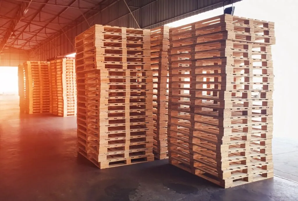 Pallets de madera apilados dentro de una nave industrial.